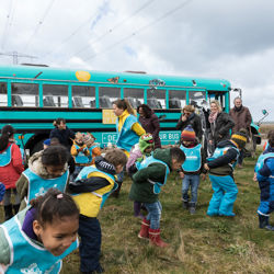 Met bus, leerlingen op strand